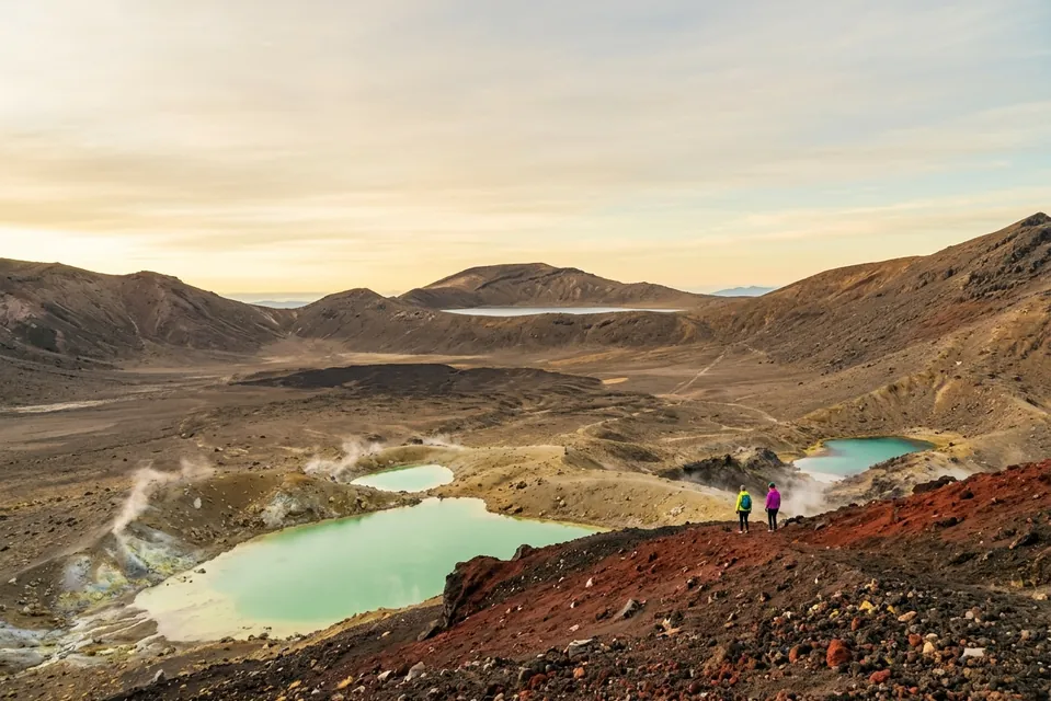 Two hikers above the steaming Emerald Lakes on the Tongariro Alpine Crossing