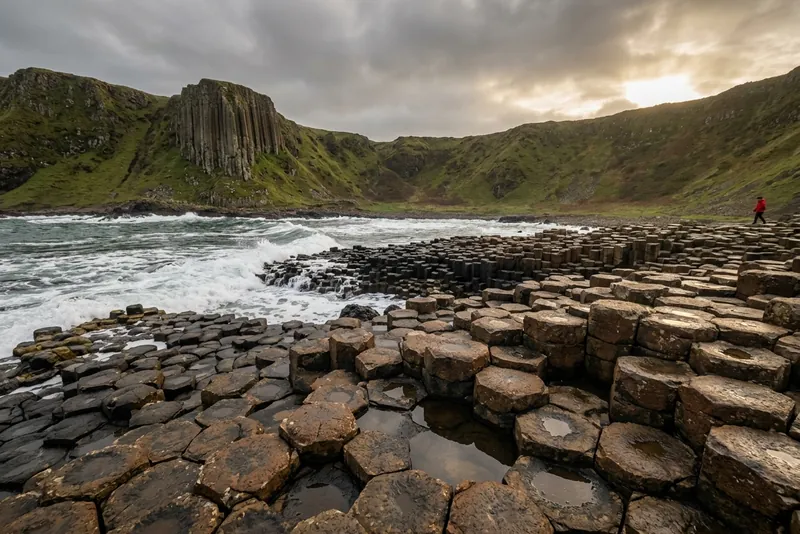 Hexagonal basalt columns of the Giant's Causeway under a stormy sky by the breaking sea