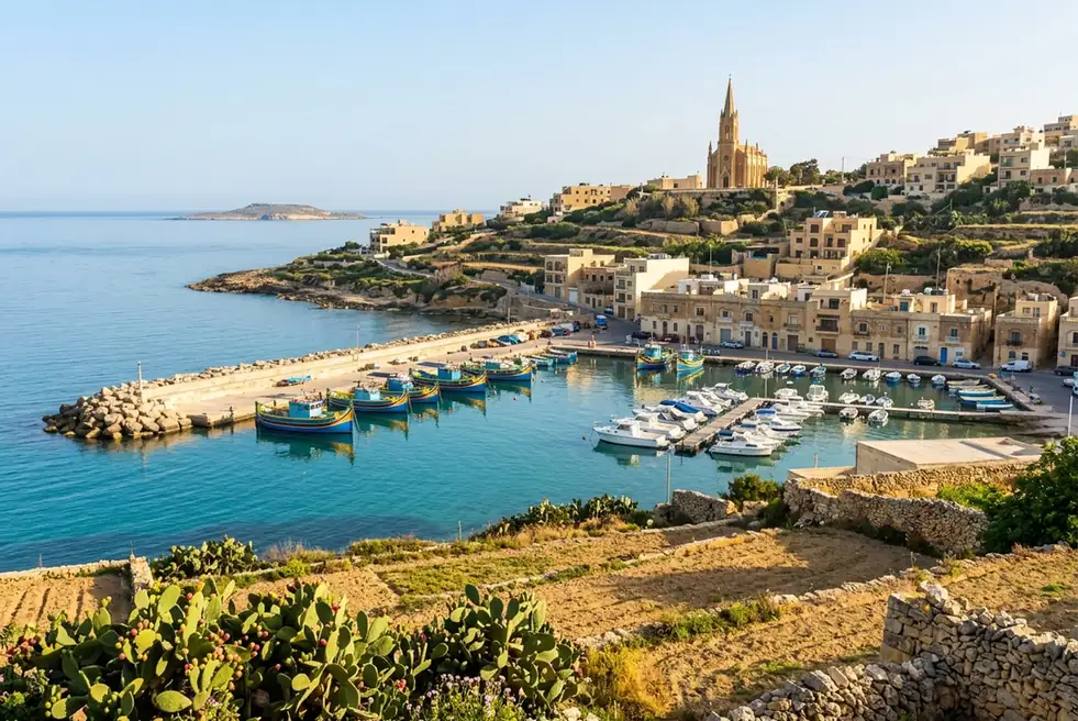 Painted fishing boats in Mġarr harbor on Gozo, below the church of Our Lady of Lourdes