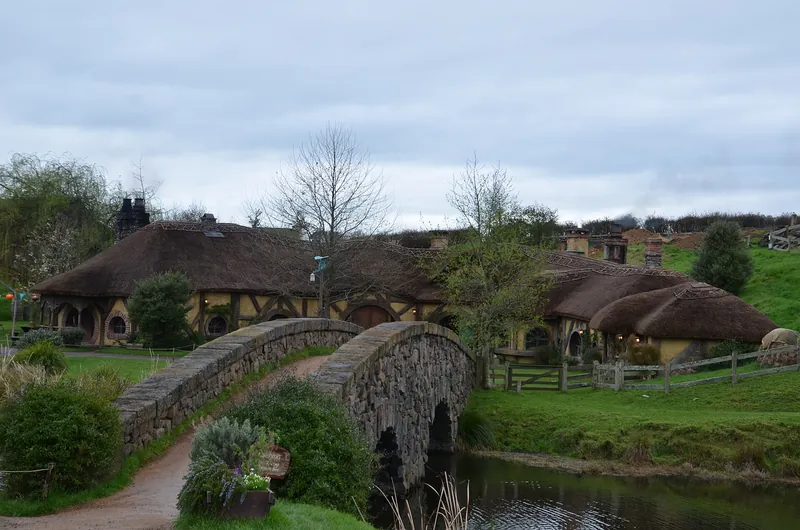 The double-arched stone bridge and the thatched Green Dragon Inn at the Hobbiton Movie Set
