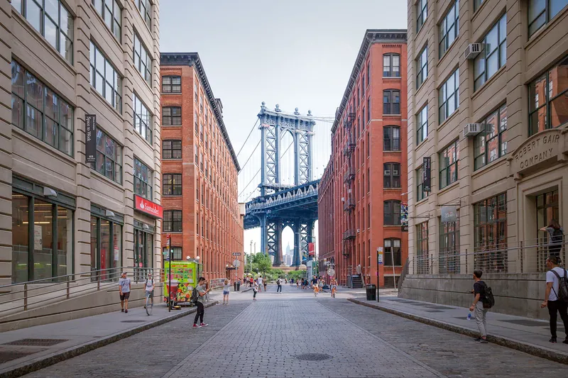 Manhattan Bridge framed between brick warehouses on Washington Street in Dumbo, Brooklyn