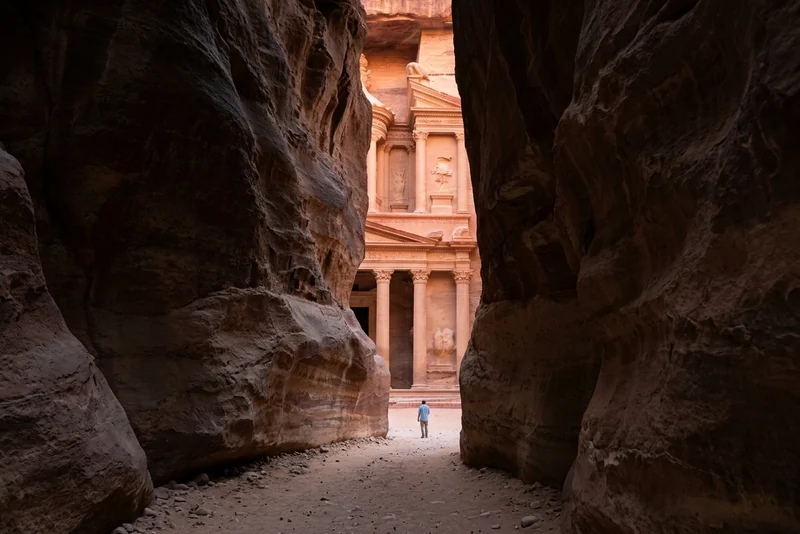 The carved facade of the Treasury at Petra seen through the narrow end of the Siq