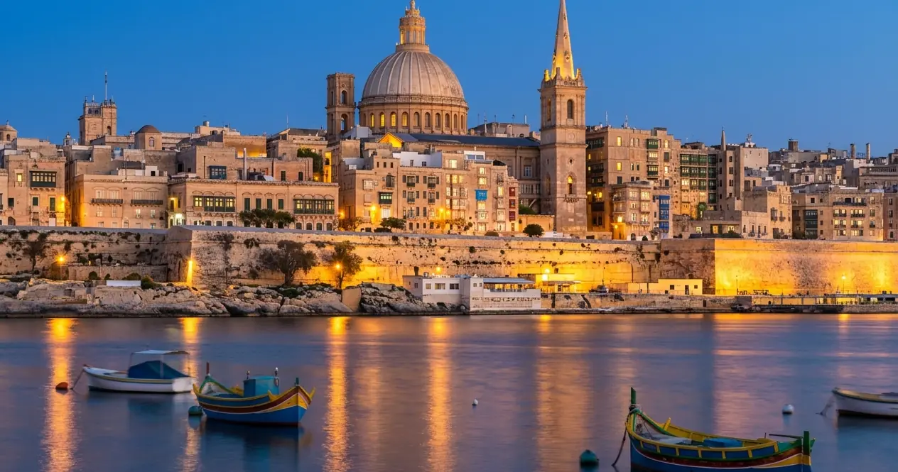 Valletta at blue hour, the Carmelite dome and St Paul's spire across Marsamxett Harbour